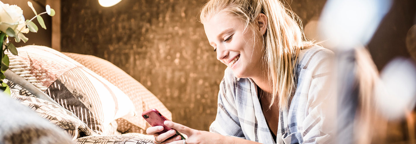 female student smiling at her phone