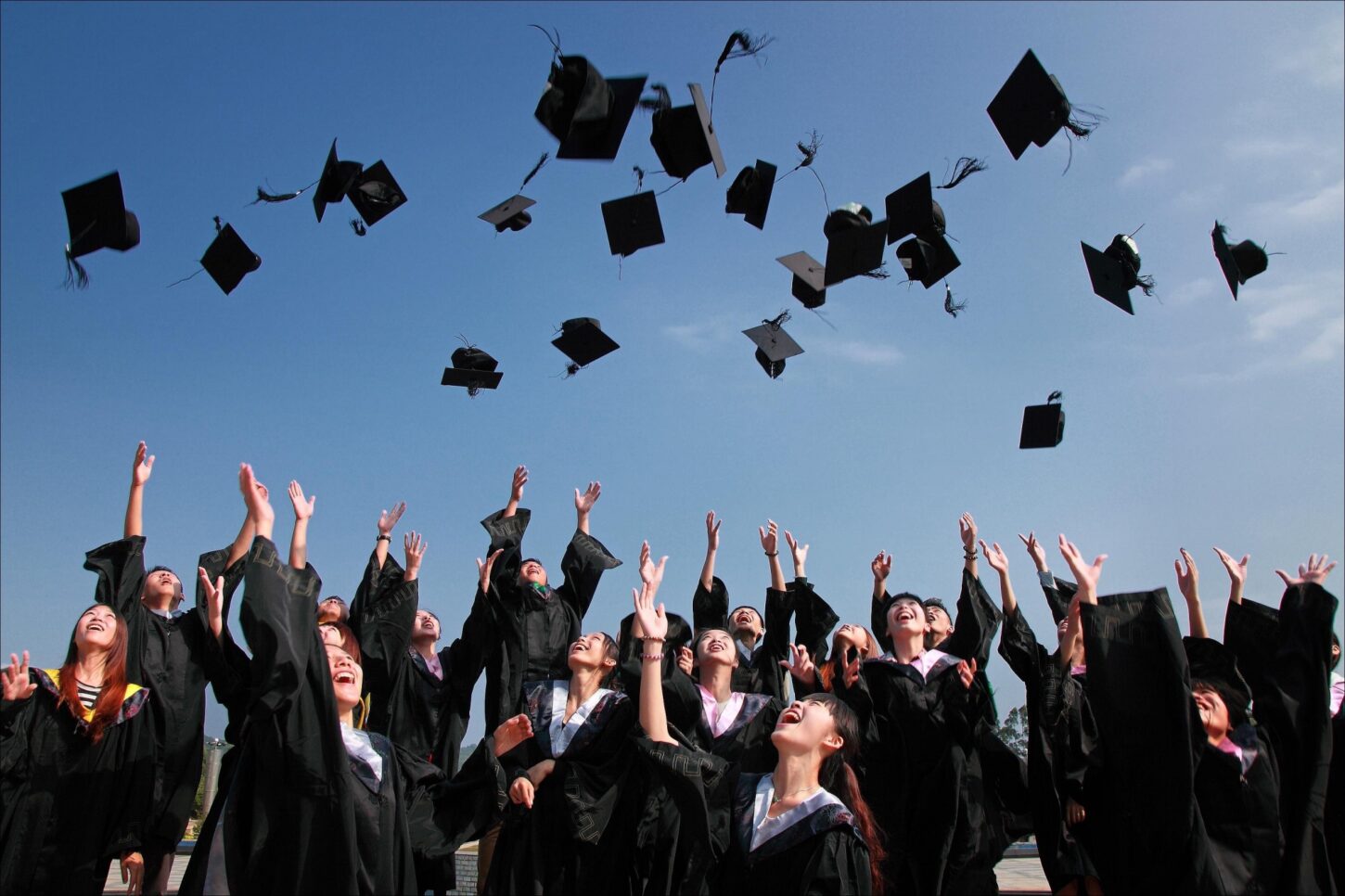 students throw graduation caps