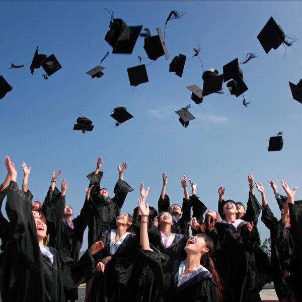 students throw graduation caps