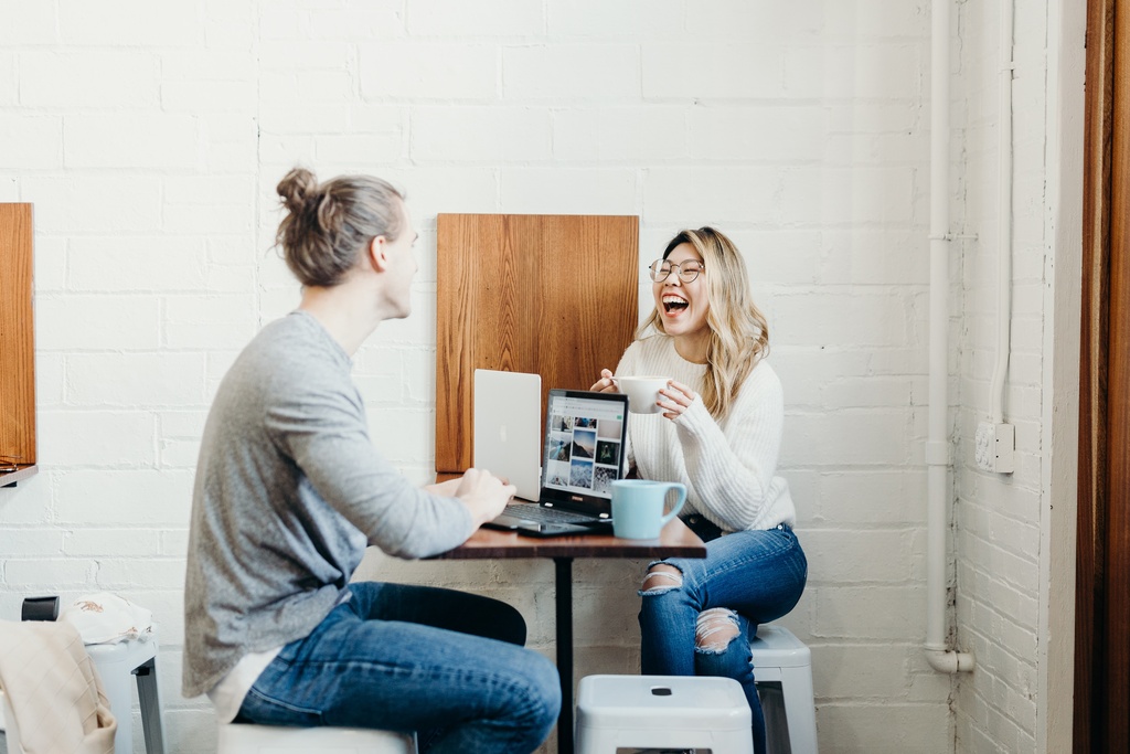 Female students are smiling and talking happily with male students. while studying together