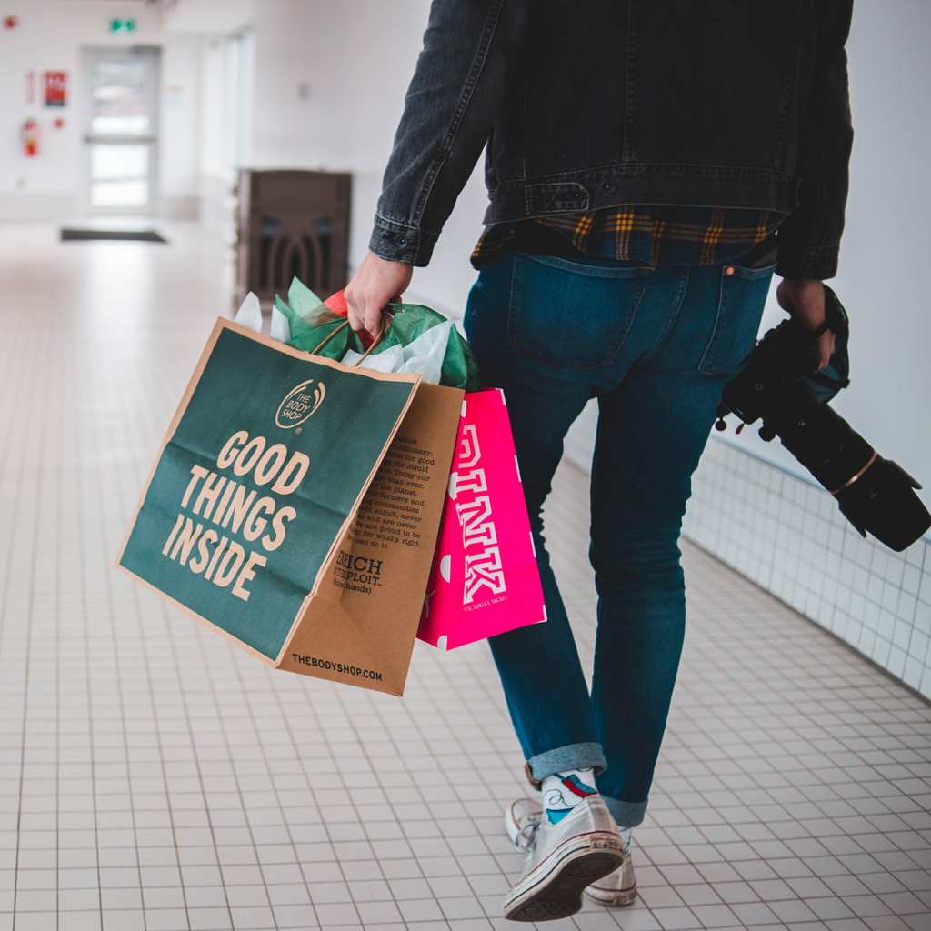 man with shopping bags and camera