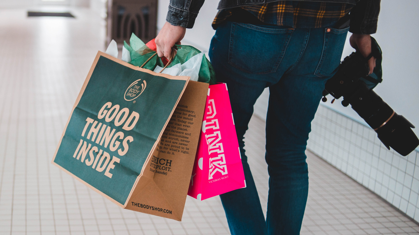 man with shopping bags and camera