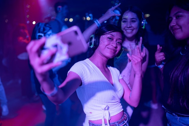 students taking selfie in night club