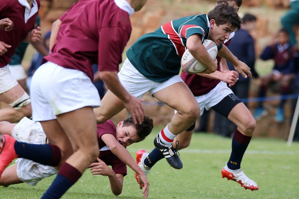 rugby player getting through tackle