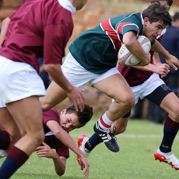 rugby player getting through tackle