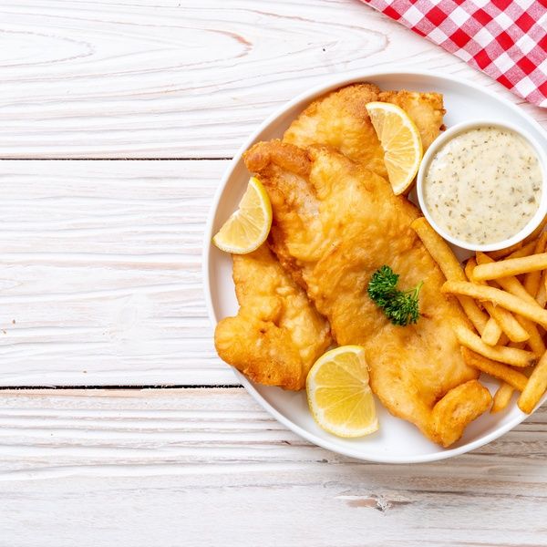 plate of fish and chips on white wood table