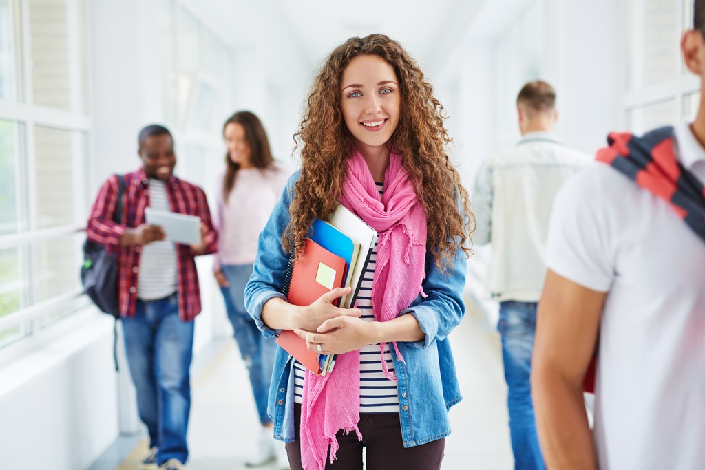 student on way to a lecture holding books