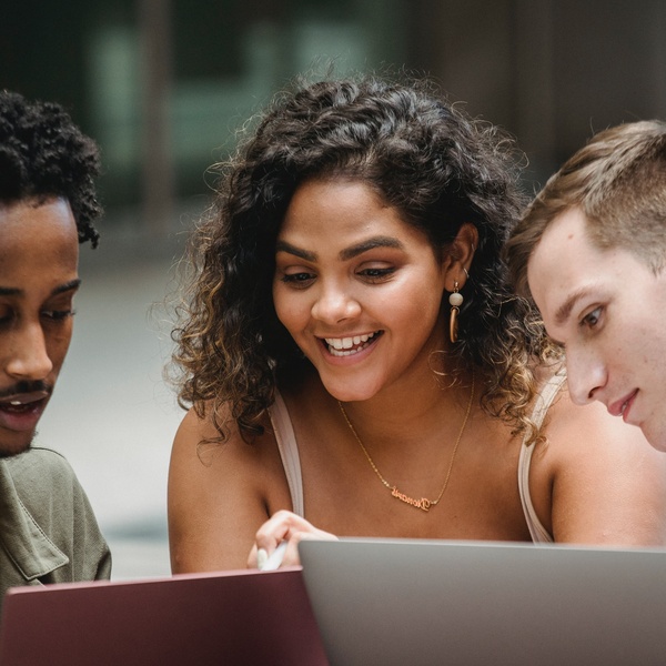 students gather around a laptop