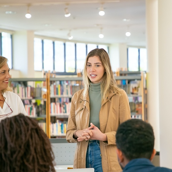 Girl talking to a group of people in a library