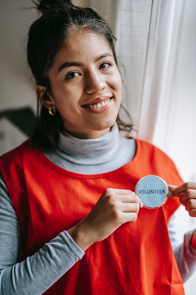Girl holding a "volunteer" badge