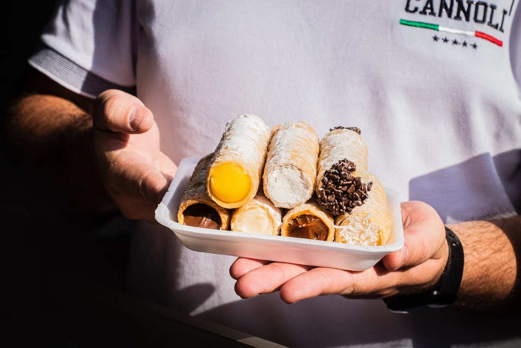 man holding cannoli