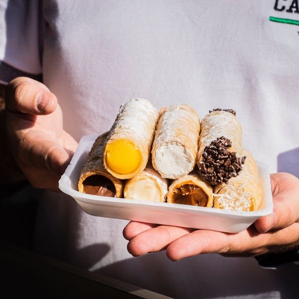 man holding cannoli