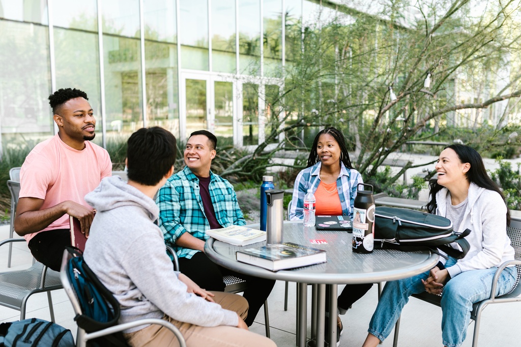 5 people sitting at table relaxing