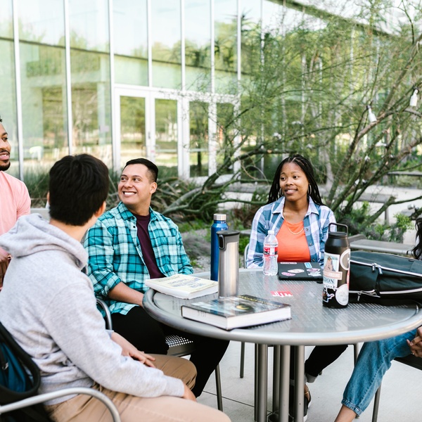 5 people sitting at table relaxing